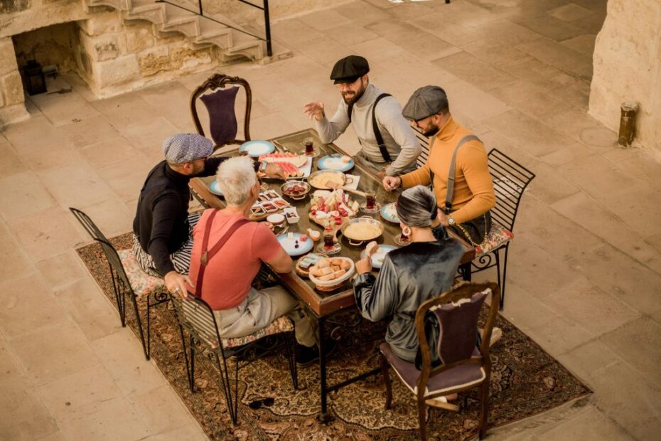 Imagem de uma mesa com cinco pessoas sentadas nas cadeiras para ilustrar conteúdo denominado de: conheça as peculiaridades da culinária francesa