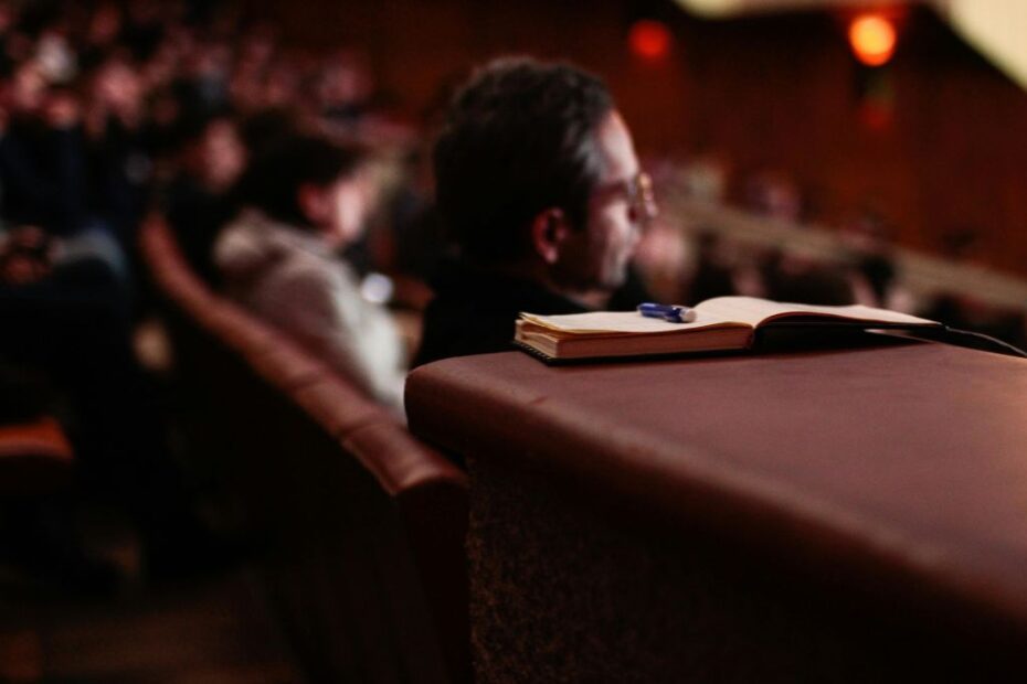 Imagem de homem em auditório assistindo a uma palestra para ilustrar conteúdo denominado tenha mais eficiência na comunicação do seu evento